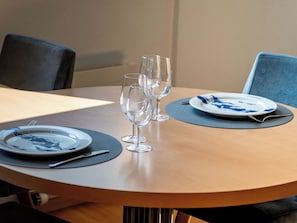 A round dining table with a plate, two wine glasses, and a fork. - Dolce Vita Appartement/Fewo 2-Bettwohnung Südlenz by Interhome (Saas-Fee)