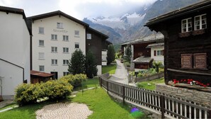 Et hotel kaldet 'Alouette' med en stensti, et træhegn og et bjerg i baggrunden.