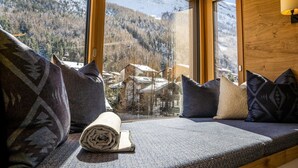 A cozy cabin interior with a window seat overlooking a snowy mountain landscape. - Riverside 24 Appartement/Fewo Appartement/Fewo by Interhome (Saas-Fee)