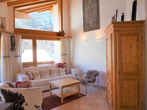 A cozy living room with a sofa, a coffee table, a chair, and a wooden cabinet. - Dominic B Appartement/Fewo 4-Bettwohnung by Interhome (Saas-Fee)