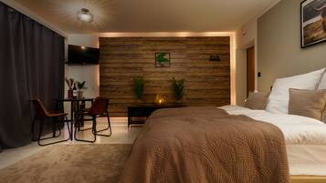 Een moderne slaapkamer met een groot bed, een bureau en een televisie.