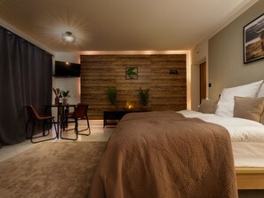 Een moderne slaapkamer met een groot bed, een bureau en een televisie.