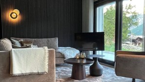 A modern living room with a sofa, a coffee table, and a TV. - Hollywood 1 Appartement/Fewo 6-Bettwohnung by Interhome (Saas-Fee)