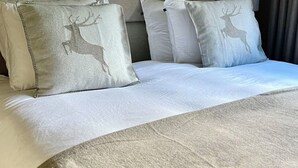 A bed with a patterned headboard, multiple pillows, and a textured blanket. - Hollywood 1 Appartement/Fewo 6-Bettwohnung by Interhome (Saas-Fee)