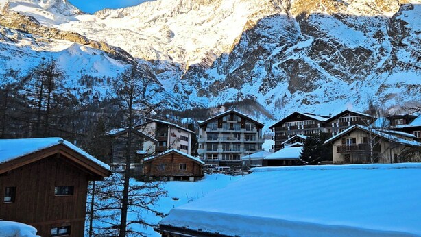 A mountain resort with wooden lodges, snow-covered roofs, and a backdrop of snow-capped peaks. - Achat 4 Appartement/Fewo 4-Bettwohnung by Interhome (Saas-Fee)