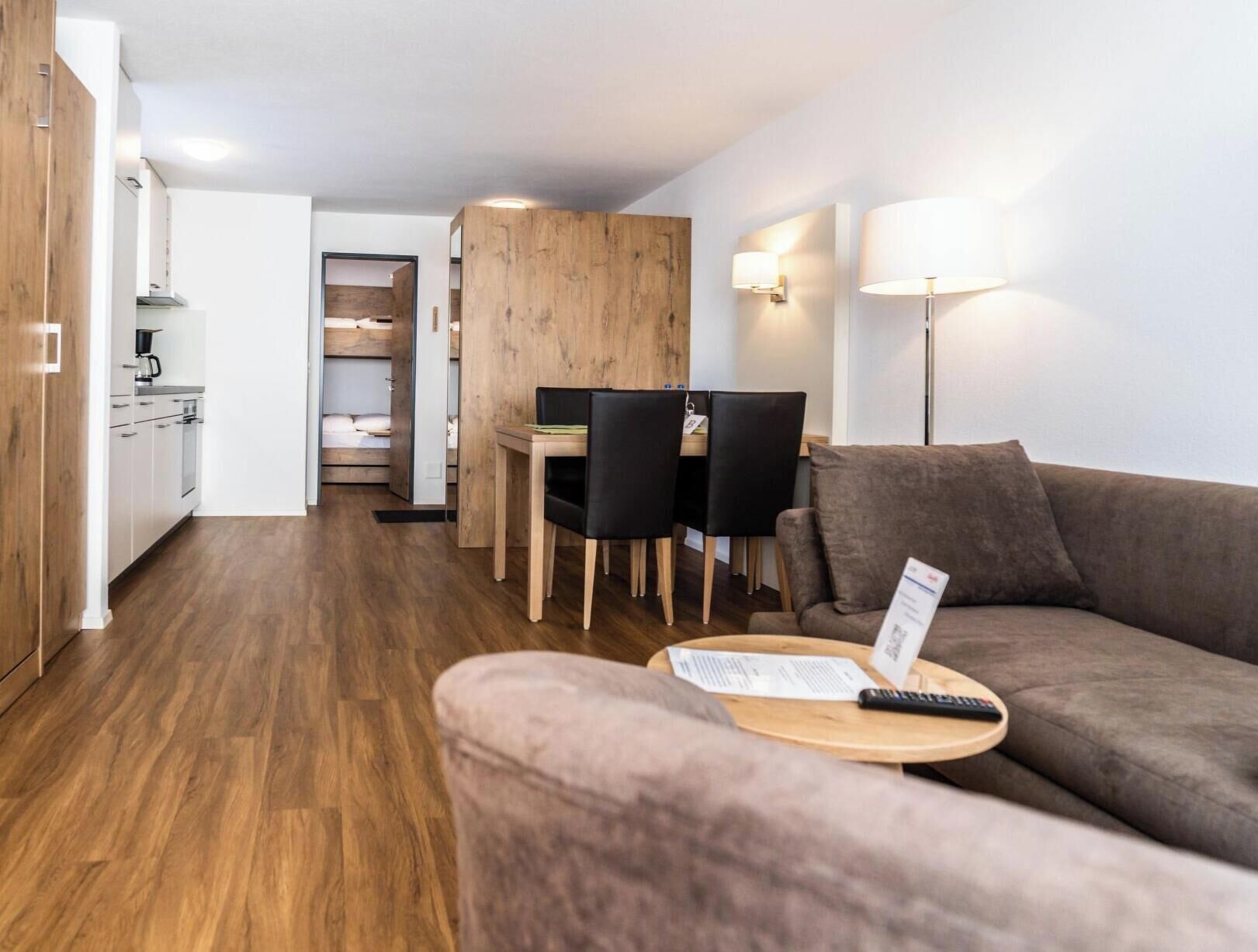 A compact living space with a kitchenette, dining area, and a sofa.