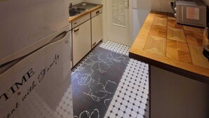 A compact kitchen with a refrigerator, sink, and toaster.
