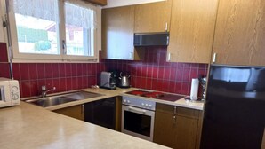 A kitchen with wooden cabinets, a stove, a sink, and a refrigerator. - Zurbuchen Adolf & Erika Appartement/Fewo 4-Bettwohnung by Interhome (Habkern)