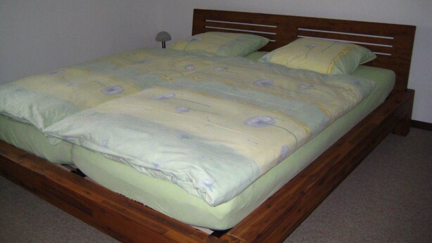 A single bed with a wooden frame and a green bedspread with a floral pattern. - Zurbuchen Adolf & Erika Appartement/Fewo 4-Bettwohnung by Interhome (Habkern)