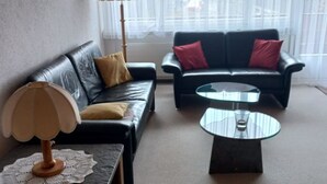 A living room with a sofa, two armchairs, a coffee table, a lamp, and a window with sheer curtains. - Zurbuchen Adolf & Erika Appartement/Fewo 4-Bettwohnung by Interhome (Habkern)