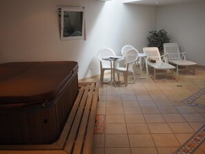 A room with a hot tub, white plastic chairs, a small table, and a potted plant. - Cornelia 3 Appartement/Fewo Appartement/Fewo by Interhome (Saas-Fee)