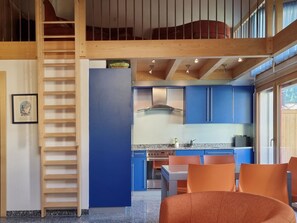 A modern kitchen with blue cabinets, a stainless steel stove, and a wooden staircase. - Snow-Fun B Penthouse Appartement/Fewo Appartement/Fewo by Interhome (Saas-Fee)