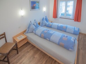 A single bed with a wooden frame and a small bedside table with a lamp. - Chalet Alpenruh Appartement/Fewo Nr. 3 Mischabel by Interhome (Saas-Fee)