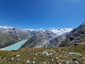 Eine Berglandschaft mit einem türkisblauen See und schneebedeckten Gipfeln.