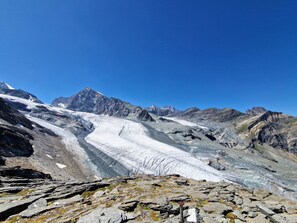 Eine Berglandschaft mit Gletscher und felsigem Gelände.