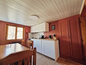 A compact kitchen with wooden cabinets, a dining table, and chairs. - Faderhorn 8 Appartement/Fewo Appartement/Fewo by Interhome (Saas-Almagell)