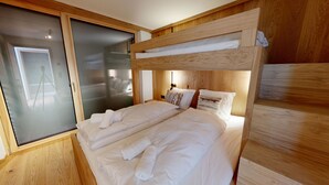 Ein Schlafzimmer mit Etagenbett, einer Schiebetür und einem hölzernen Kopfteil.