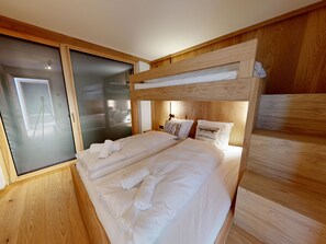 A bedroom with a bunk bed, a sliding door, and a wooden headboard. - Alphubel Peak & Unlimited Appartement/Fewo Peak 07 by Interhome (Saas-Fee)