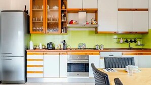 Uma cozinha equipada com frigorífico, forno e armários.