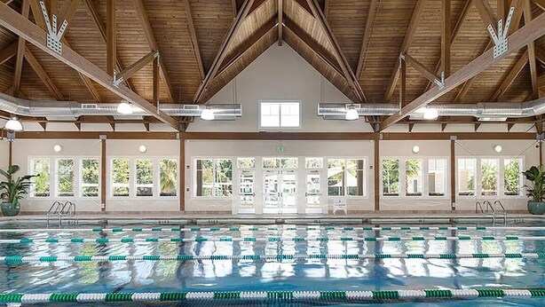 An indoor swimming pool with clear lanes, wooden beams, and large windows. - Cozy 1-bedroom condo in private Seabrook Island with 2 queen beds. (Seabrook Island)