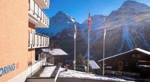 Ein Hotel mit Blick auf die Berge, einer Fahnenstange und einem Gebäude mit Balkon.