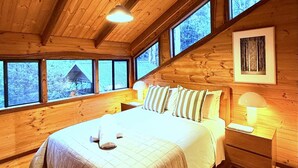 A wooden cabin bedroom with a bed, nightstands, and a window view. - Inglenook: Cosy forest escape, 5min to Denmark (Denmark)