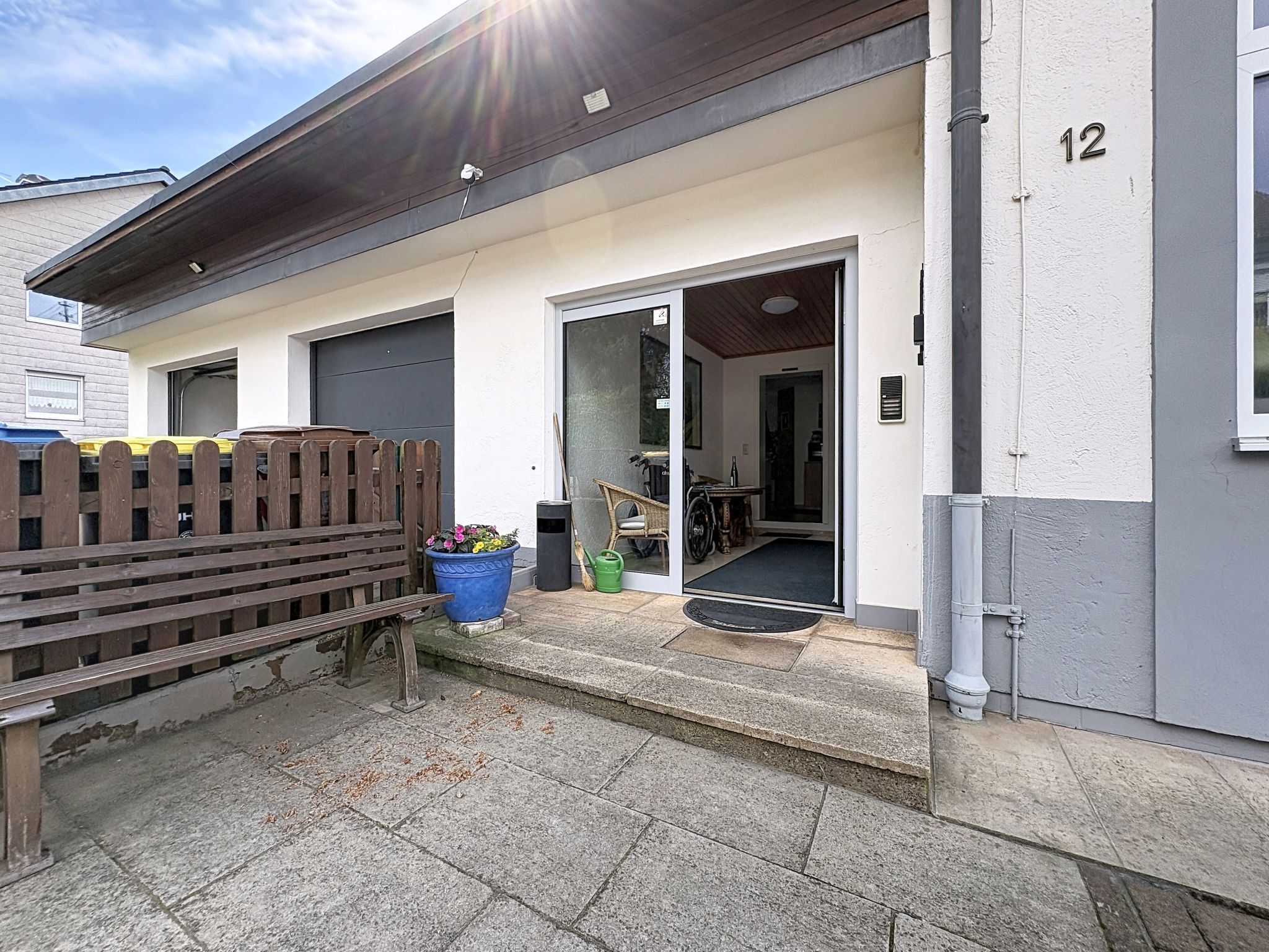Ein Wohngebäude mit Garage, Holzzaun und einem blauen Blumenkasten.