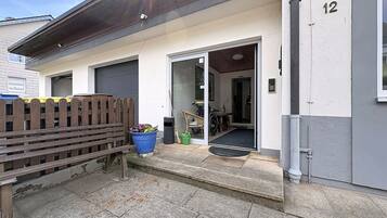 Ein Wohngebäude mit Garage, Holzzaun und einem blauen Blumenkasten.