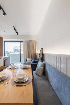 A modern hotel room with a dining area, a sofa, and a view of the city. - Myla Girasol  (Ciudad de México)