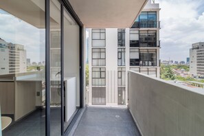 Eine moderne Wohnung mit Balkon, großen Fenstern und Blick auf andere Gebäude.