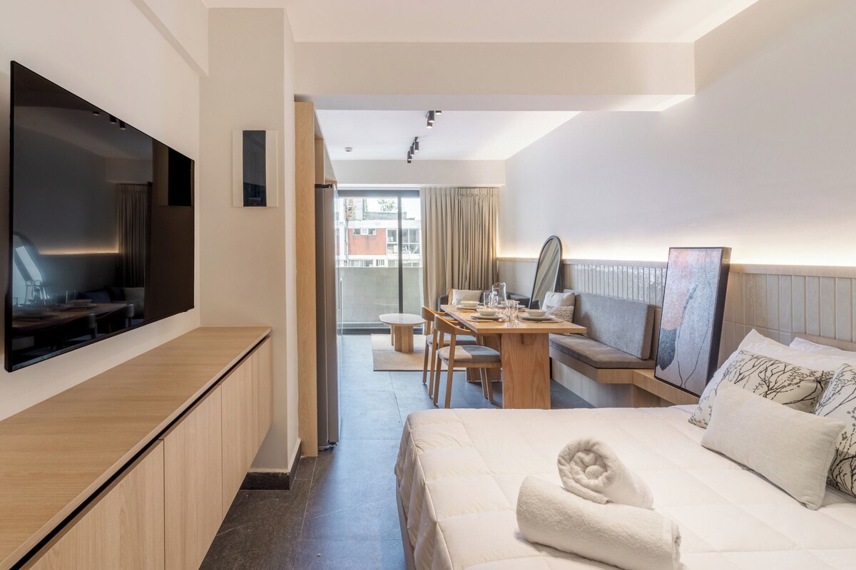 Ein Hotelzimmer mit Bett, Fernseher, Schreibtisch und Essecke.
