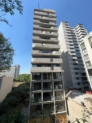 Un edifici de diverses plantes amb un disseny arquitectònic modern, que destaca per una sèrie de balcons i grans finestres.