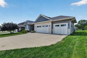 Ein Wohnhaus mit Garage, Auffahrt und gepflegtem Rasen.