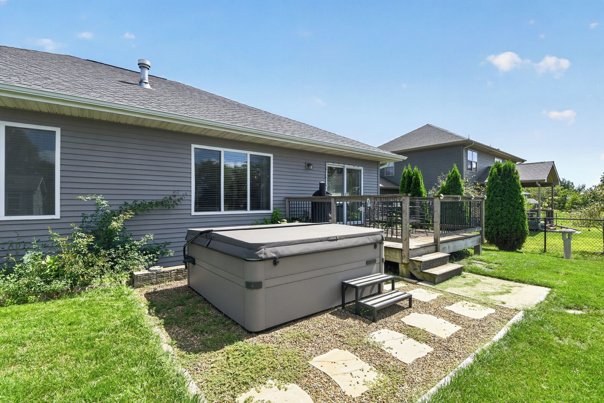 Une maison d’habitation dotée d’un patio couvert, d’un jacuzzi et d’une cour clôturée.