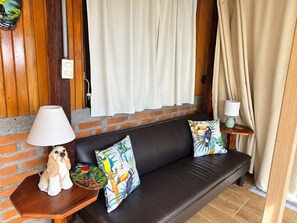 A room with a brown leather sofa, two side tables with lamps, and a decorative dog figurine on one table.