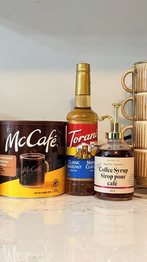 A box of McCafe coffee, a bottle of Torani hazelnut syrup, and a bottle of coffee syrup. - Cozy, pet friendly retreat close to Niagara Falls | sleeps 8 (Thorold)