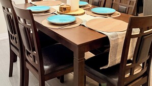 Ein Essbereich mit Holztisch, Stühlen und einer Pendelleuchte.
