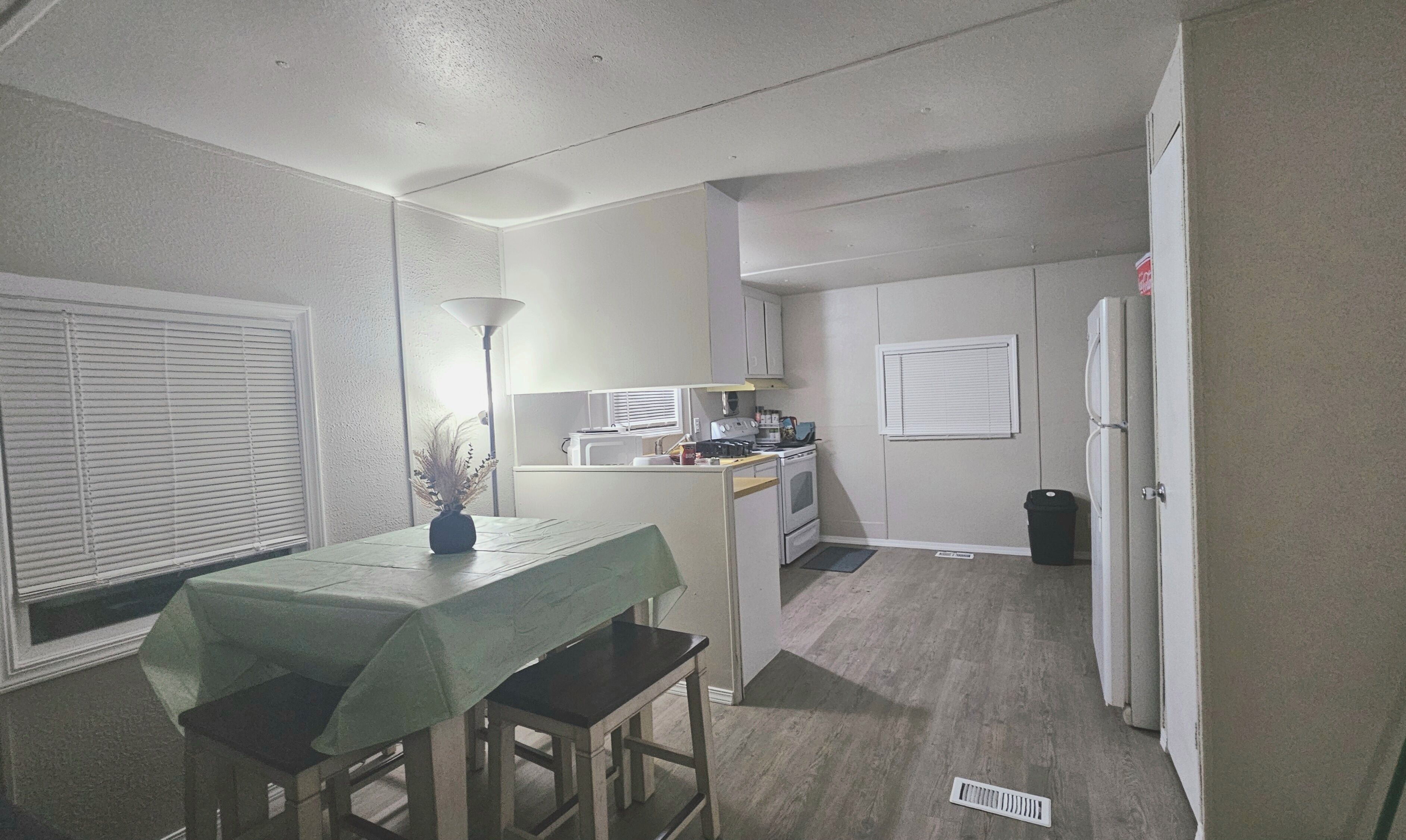 A compact kitchen with a dining area, a microwave, a stove, and a refrigerator.