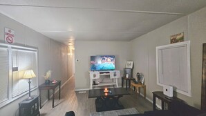 Ein Wohnzimmer mit Fernseher, Tisch und einem Rauchverbot-Schild an der Wand.