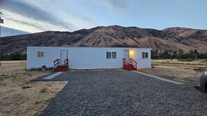 Ein Bungalow mit Kiesweg und Bergblick im Hintergrund.