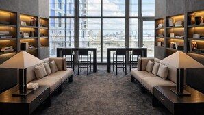 Un interior moderno con vista a la ciudad, dos sofás, una mesa y estanterías.