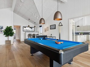 A pool table with balls, a bar area, and a dining space with chairs. - 5 Star Holiday Home in Idestrup (Idestrup)