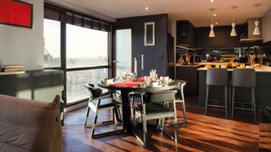 Una cocina moderna con comedor, ventanas amplias y vista a la ciudad.