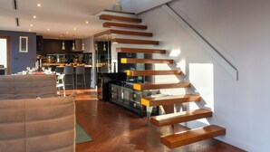 Un interior moderno con una escalera, una zona de comedor y una cocina.