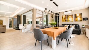 A modern living room with a dining area, a sofa set, and a fireplace. - Villa Rudiae by Symphonya Rentals (Lequile)