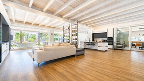 A spacious living area with a sofa, a kitchen, and a dining area. - Villa Rudiae by Symphonya Rentals (Lequile)