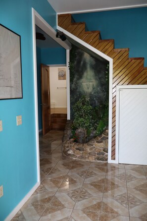 A staircase with wooden steps leading to a landing, a blue wall, and a tiled floor. - Caribbean Dream Retreat (Utila)