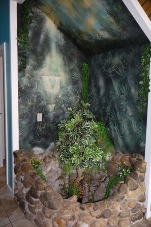 A stone wall with a small plant and flowers. - Caribbean Dream Retreat (Utila)