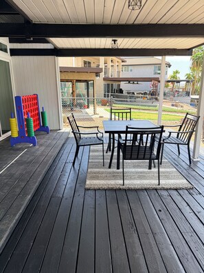 An outdoor patio with a table and chairs, a children's play structure, and a view of the surrounding area.
