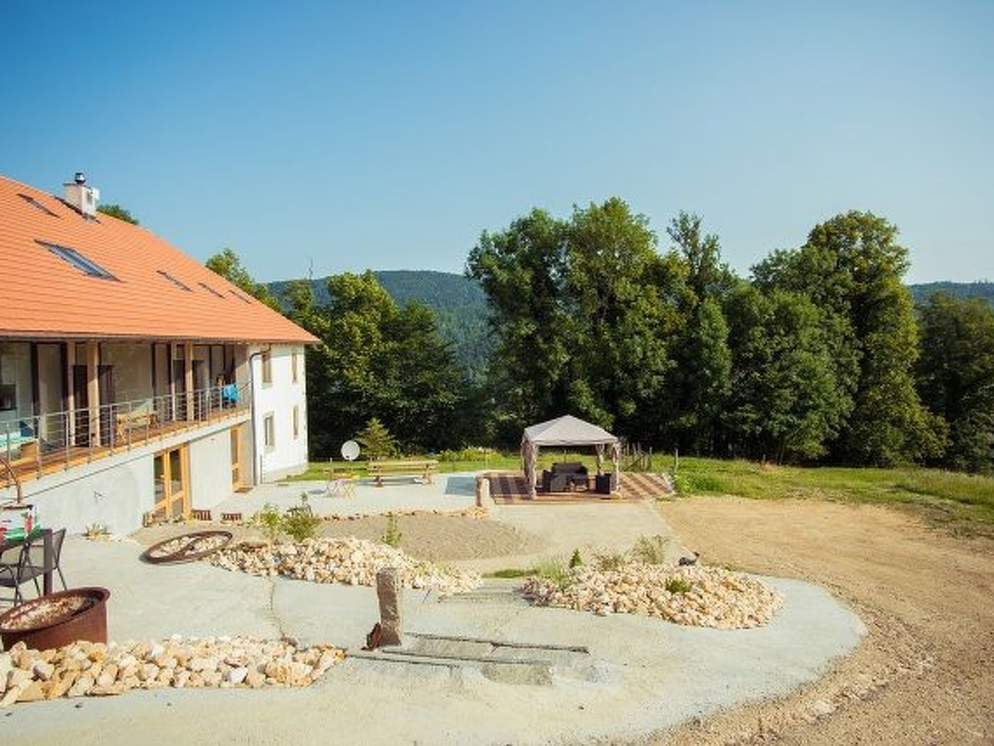 Una casa amb una galeria coberta, una piscina i un camí de pedra.